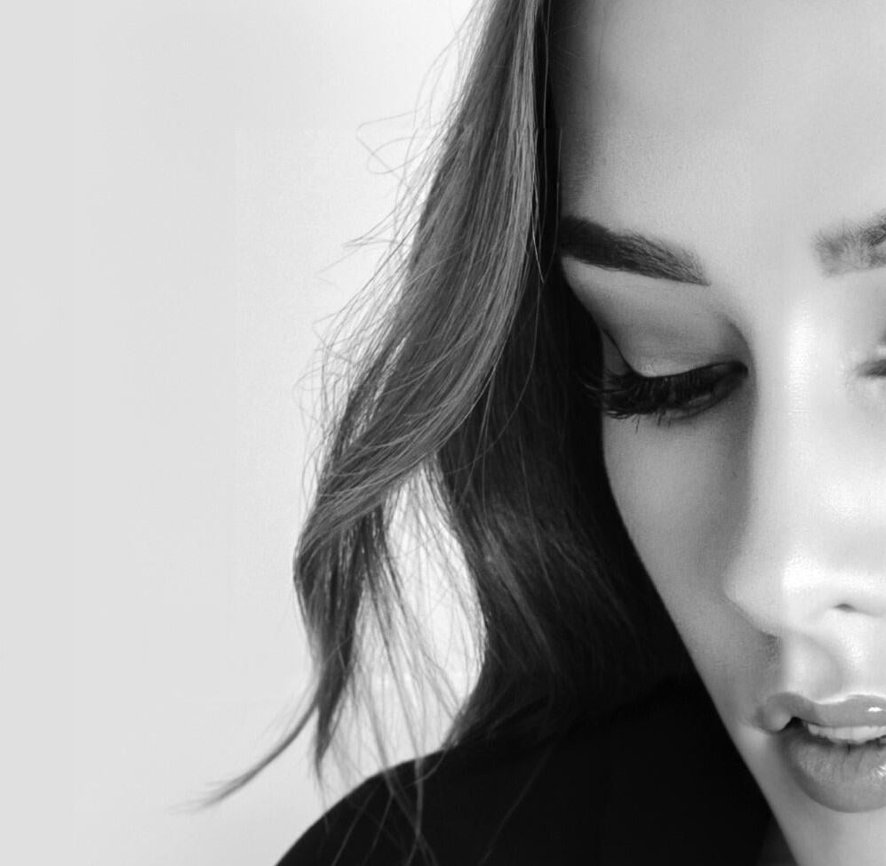 Black and white close-up of a person's face with a neutral expression.